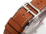 a close up of a watch with a brown leather strap