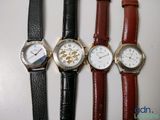 four different watches are lined up on a white surface