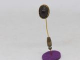 gold plated earring with a purple base and a black stone