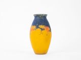 un vase jaune et bleu posé sur une surface blanche