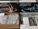 two boxes of star trek miniatures sit side by side on a black background