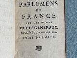 an open book on a blue surface with a black and white title
