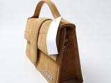 leather handbag made of brown crocodile skin with a white ribbon