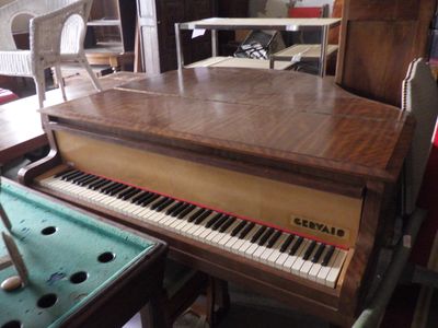 a piano that is sitting in a room with a pool table