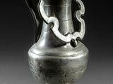 un vase en argent posé sur une table