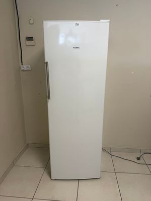 un réfrigérateur blanc dans le coin d'une pièce