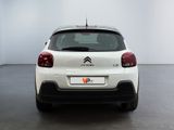 the rear end of a white citrole parked in a white room