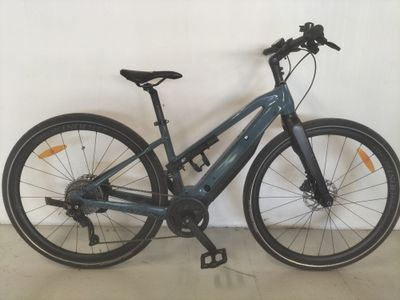 un vélo bleu appuyé contre un mur blanc