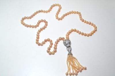 Un long collier en perles de culture couleur rose avec au bo…