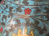 a blue vase with a yellow and red flower on it