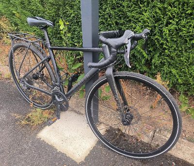 un vélo attaché à un poteau au bord de la route