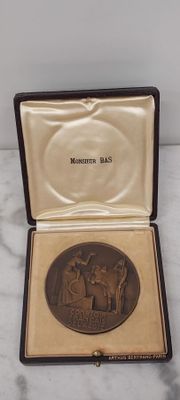 une petite boîte contenant une médaille, posée sur une surface en marbre