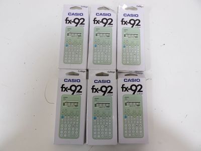quatre boîtes de calculatrices posées sur une table blanche