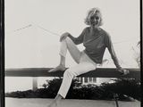 photographie en noir et blanc d'une femme assise sur un banc