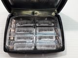 a black case with six clear razors inside of it