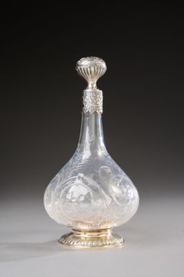 un flacon de parfum en verre transparent, muni d'un bouchon et d'un socle argentés