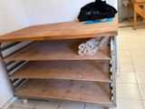 a wooden shelf that has two rolls of toilet paper on top of it
