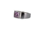 a close up of a ring with a purple stone in it
