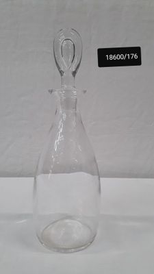 a clear glass bottle with a handle on a white table