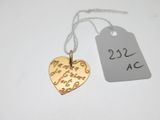un pendentif en forme de cœur en or auquel est attachée une étiquette de prix
