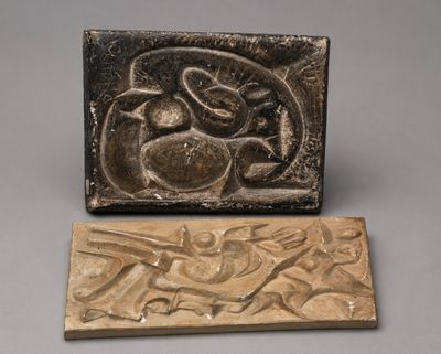 une plaque en bronze sur laquelle figurent un oiseau et un poisson