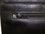 black leather purse with a zipper on the inside of it