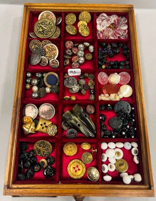 une boîte en bois remplie d'une multitude de boutons de toutes sortes