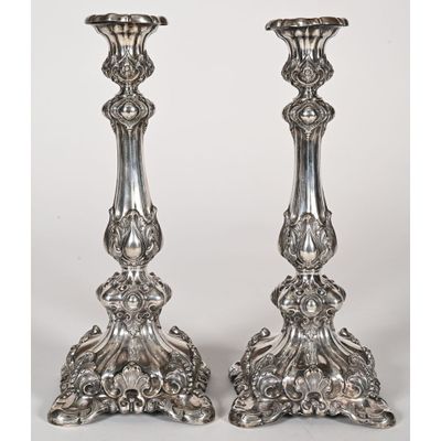 a pair of silverplated candlesticks with ornate designs