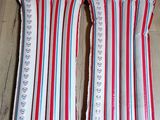 une paire de coussins rayés de rouge, de blanc et de bleu posés sur un parquet