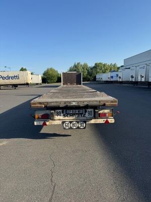 un camion à plateau garé sur un parking