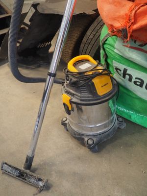 un aspirateur posé par terre à côté d'un sac