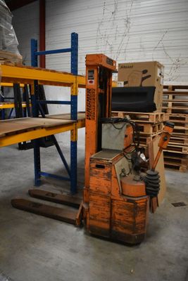 an image of a forklift in a warehouse with pallets and boxes