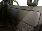 the interior of a car with the door open and the driver ' s seat down