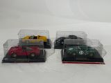 three toy cars in a display case on a white surface