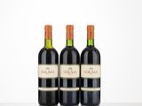 three bottles of red wine sitting on top of a table
