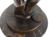 a bronze statue of a person holding a coin