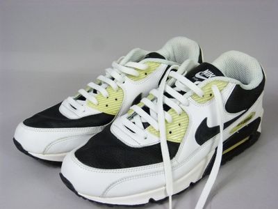 une paire de baskets noires et blanches rehaussées de touches jaunes