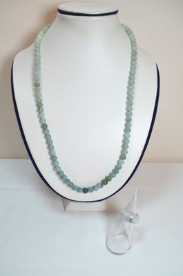 Ensemble collier et boucles d'oreilles avec des perles de verre vertes, présenté sur un mannequin blanc