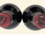 two bottles of wine sitting next to each other on a table