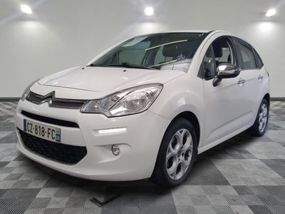 la petite voiture blanche est garée sur un sol en damier