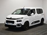 la camionnette blanche est garée dans une pièce au sol en damier