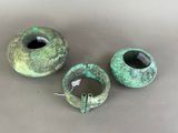 three pieces of green pottery sitting on top of a table