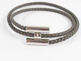 a close up of a brown leather bracelet with two silver bars