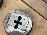 a close up of a metal button on a wooden table