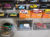 many different types of toy cars on display in a case