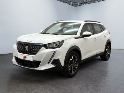 Un SUV blanc est garé dans une pièce au sol noir.