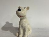 a small white dog figurine sitting on a white surface