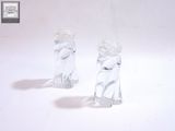 deux figurines en verre posées sur une surface blanche