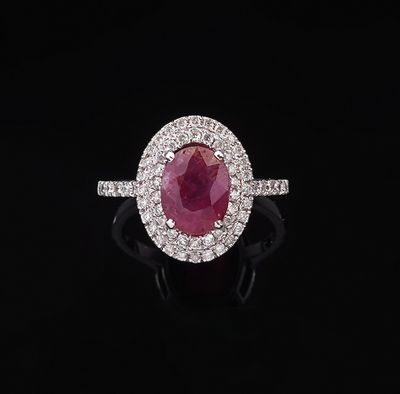 an oval ruby and diamond ring on a black background