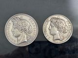 a close up of two silver coins on a black surface